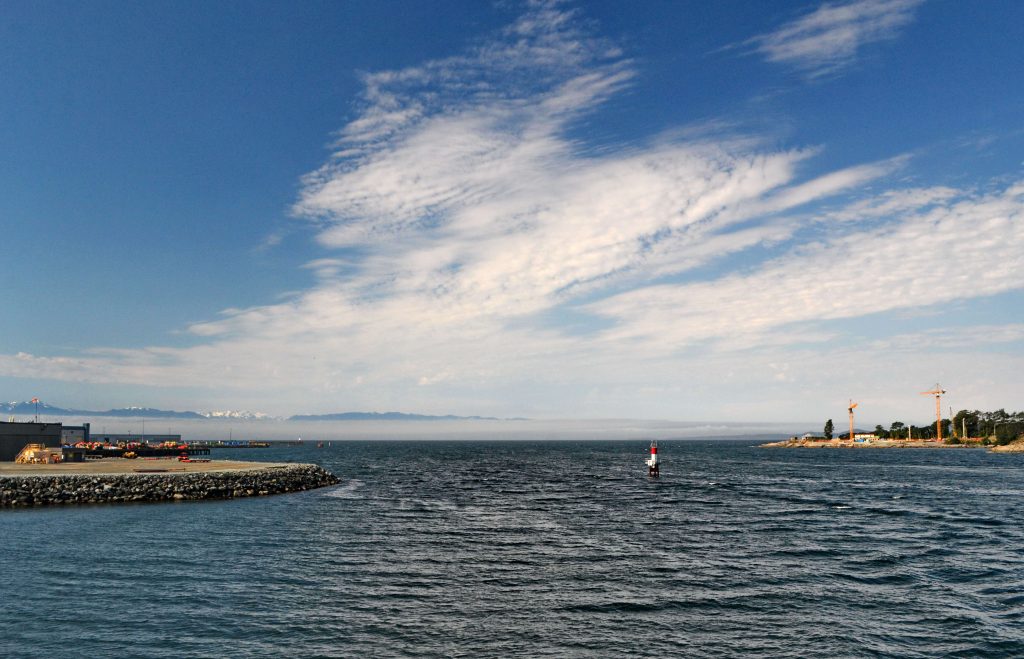 Loď COHO práve vplávala do prístavu Victoria. Americké pobrežie tvoril len úzky pás hmly, z ktorej vyčnievali zasnežené končiare pohoria Olympik